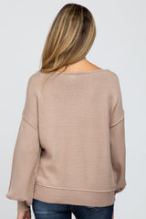 woman wearing a light brown oversized knit maternity sweater from the back, with cozy long sleeves and a relaxed fit
