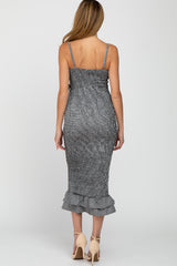 woman wearing a black and white striped maternity dress with a ruffled hem and adjustable straps