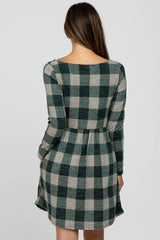 woman wearing a green and beige plaid long sleeve maternity dress from the back