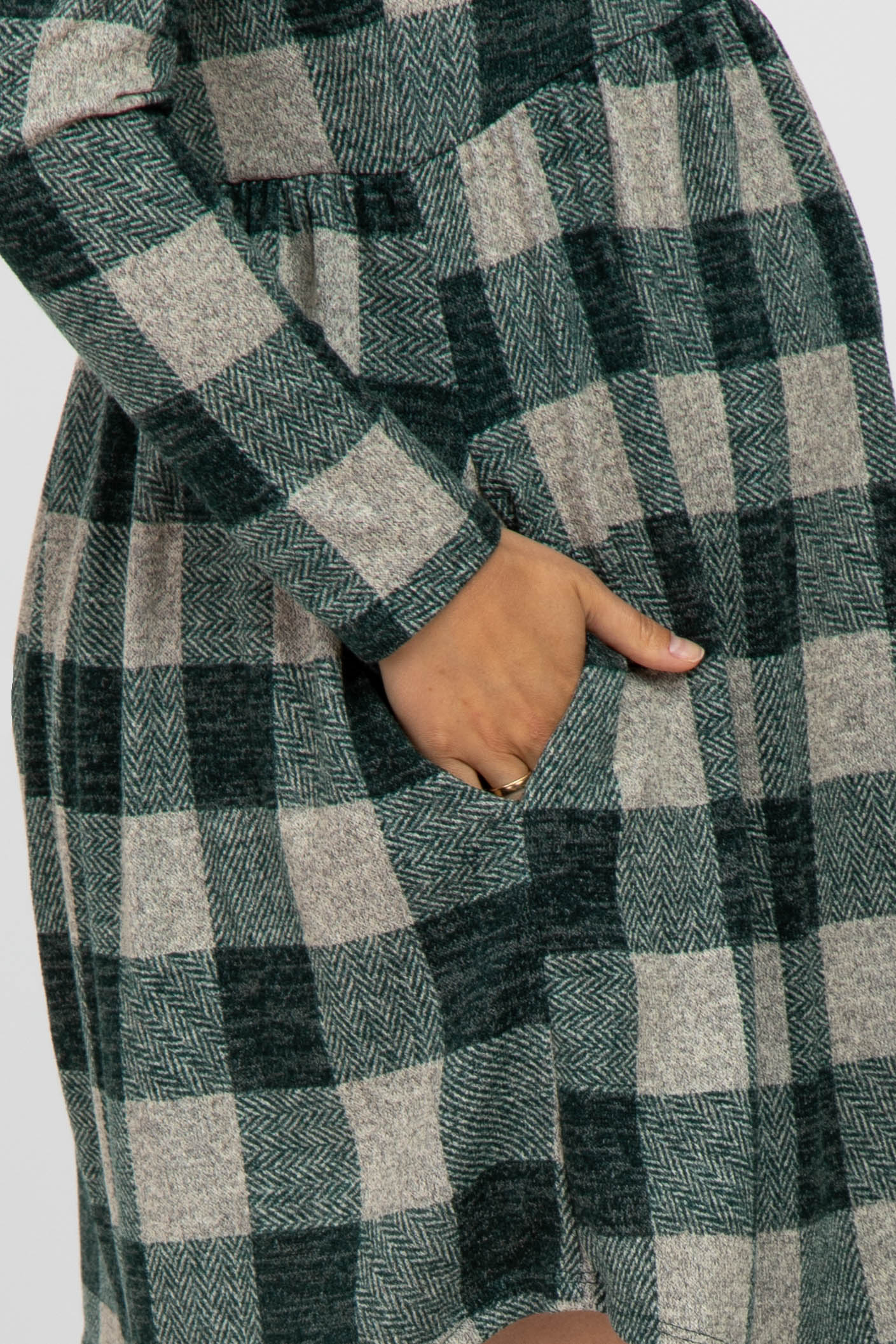 maternity wear in a green and beige plaid long sleeve dress with side pockets and a relaxed fit