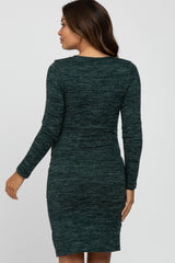 woman wearing a green long sleeve maternity dress with a fitted silhouette and side slit detail