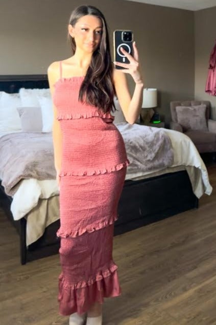 woman taking mirror selfie wearing a pink smocked tiered maxi dress in a bedroom