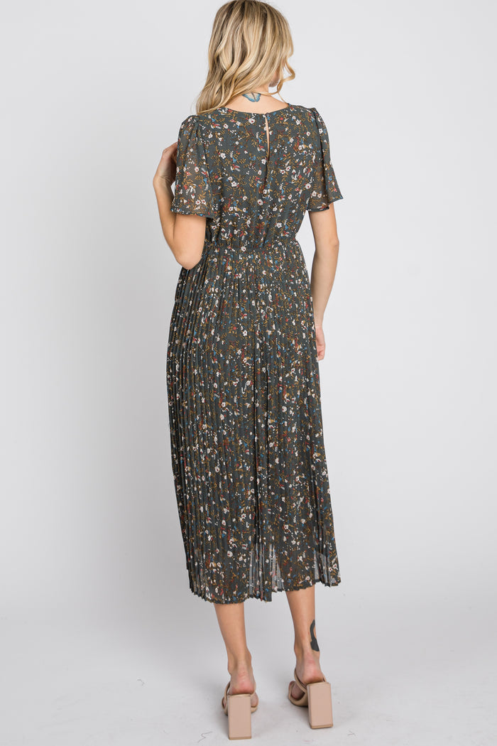 woman wearing a floral pleated midi dress with short sleeves, seen from the back