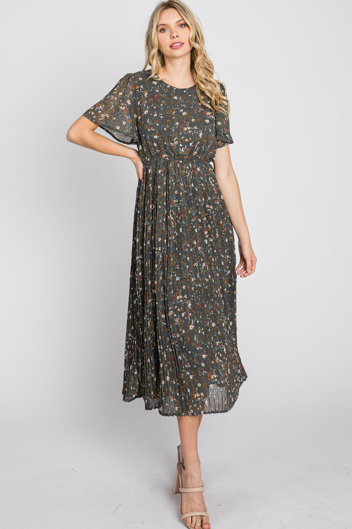 woman wearing a dark green floral maxi dress with short sleeves and a pleated skirt