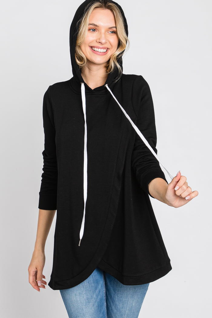 woman wearing a black long sleeve hoodie with a wrap design and white drawstrings paired with blue jeans