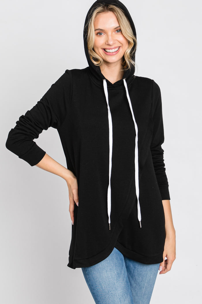 woman wearing a black hooded pullover with white drawstrings and long sleeves, paired with blue jeans