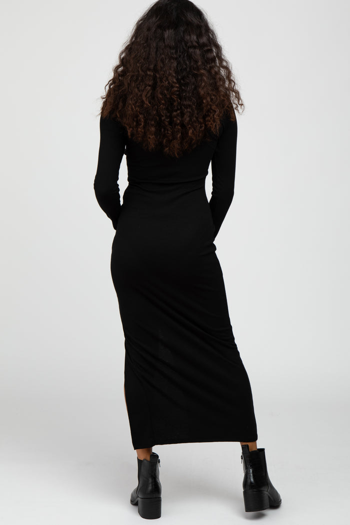 woman wearing a fitted black long sleeve maxi dress, showing the back view, styled with black ankle boots