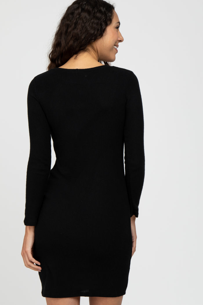 woman wearing a black ribbed long sleeve dress, shown from the back