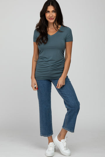 woman wearing a slate blue v-neck short sleeve top tucked into cropped jeans and white sneakers