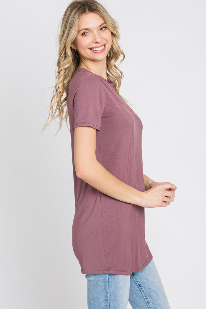 woman wearing a mauve short sleeve tunic top with a relaxed fit and smiling