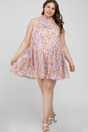 woman wearing a plus size floral halter neck tiered mini dress with white block heel sandals