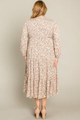 woman wearing a floral print plus size midi dress with long sleeves and a tiered skirt, seen from the back