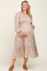 woman wearing a floral print maternity dress with three-quarter sleeves and a visible baby bump