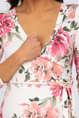 woman wearing a floral maternity wrap dress with a deep v-neck and long sleeves, highlighting a baby bump