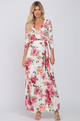 woman wearing a floral print wrap maxi dress with three-quarter sleeves and a tie at the waist
