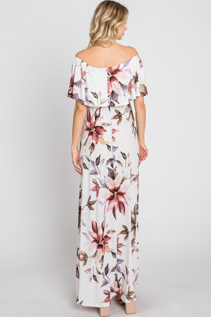 woman wearing a white off-the-shoulder maxi dress with floral prints, showing the back view