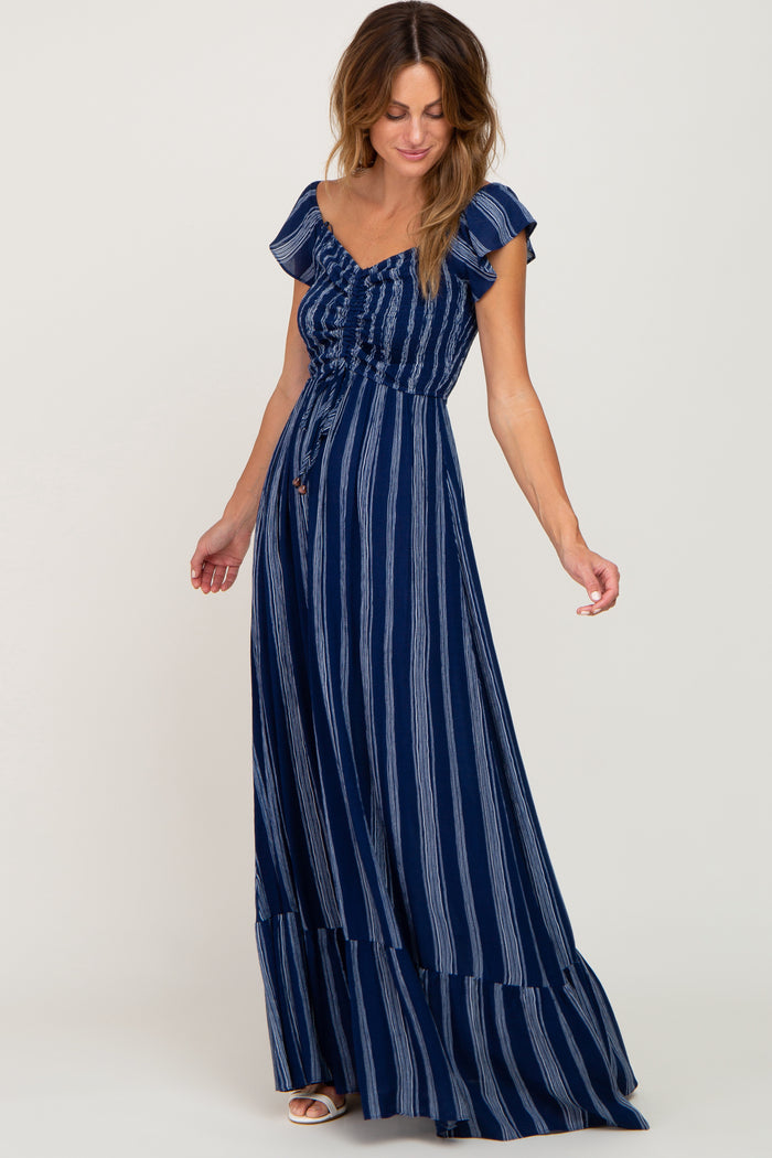 woman wearing a navy blue striped maxi dress with ruffled sleeves and a tiered skirt