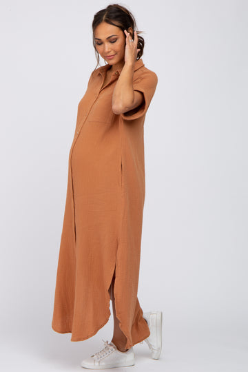 Pregnant woman wearing a short sleeve camel gauze maternity maxi shirt dress and white sneakers