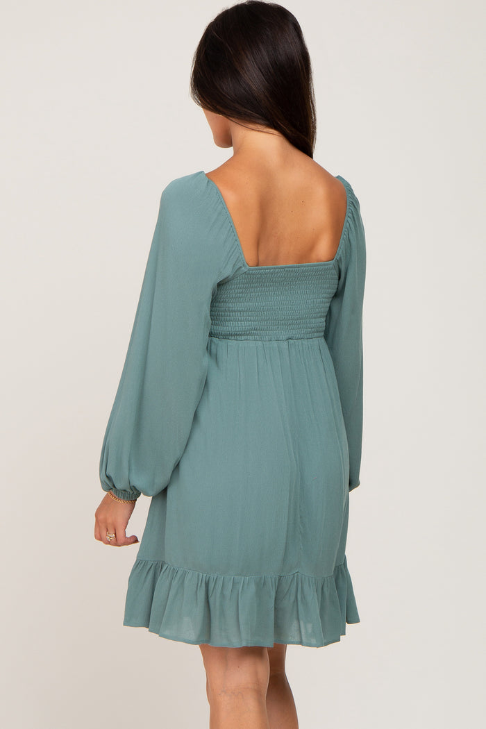 woman wearing a teal smocked back short dress with long puff sleeves and ruffled hem
