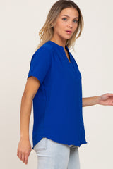 woman wearing a short sleeve royal blue v-neck blouse and light wash jeans