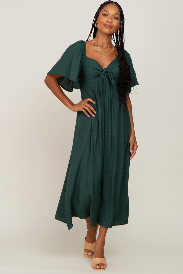 woman wearing a dark green midi dress with short flutter sleeves and a front knot detail