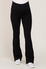 woman wearing black maternity leggings with a flared hem and a stretchy waistband