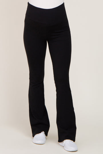 woman wearing black maternity leggings with a flared hem and a stretchy waistband