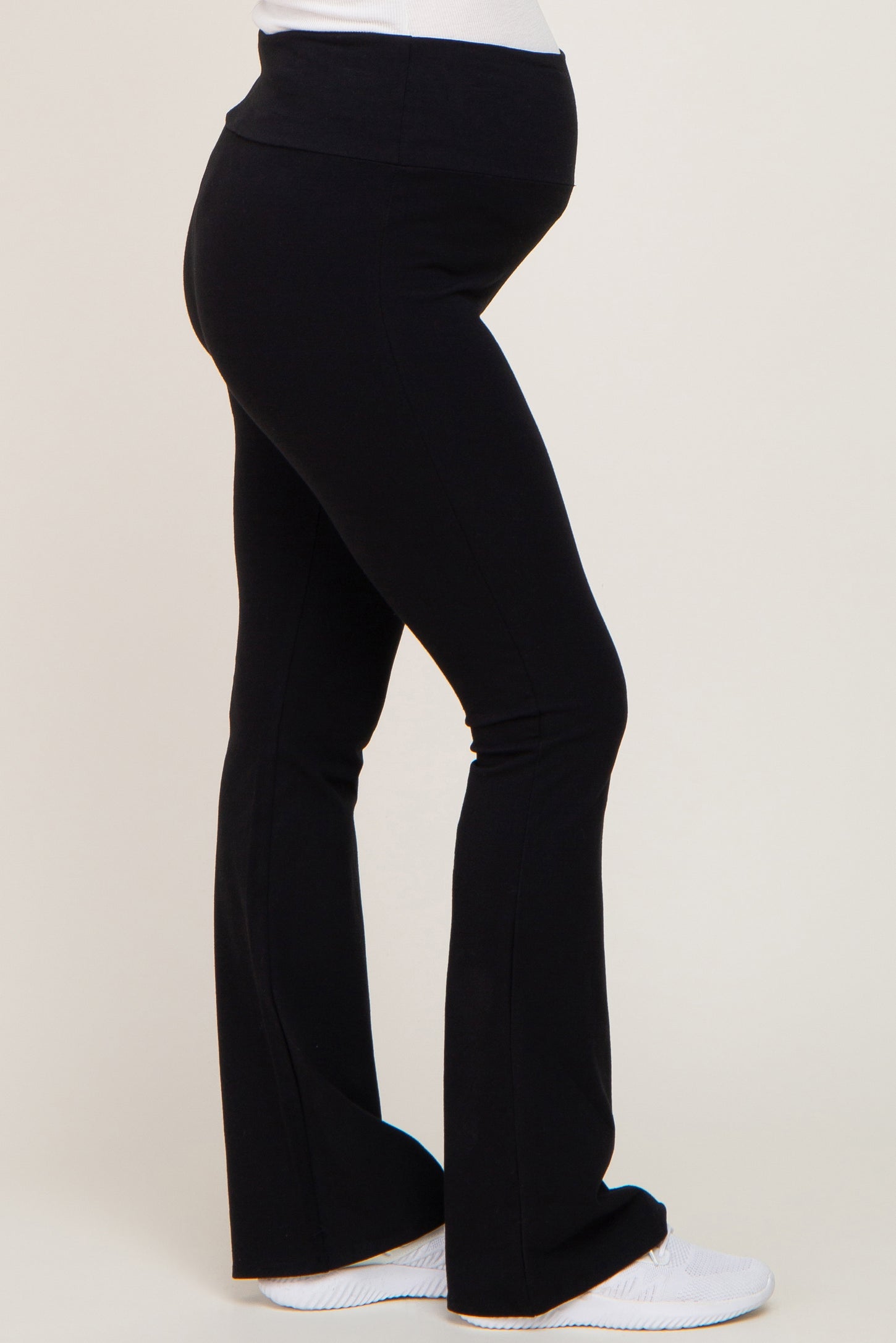 woman wearing black maternity flared leggings with a comfortable waistband and visible baby bump
