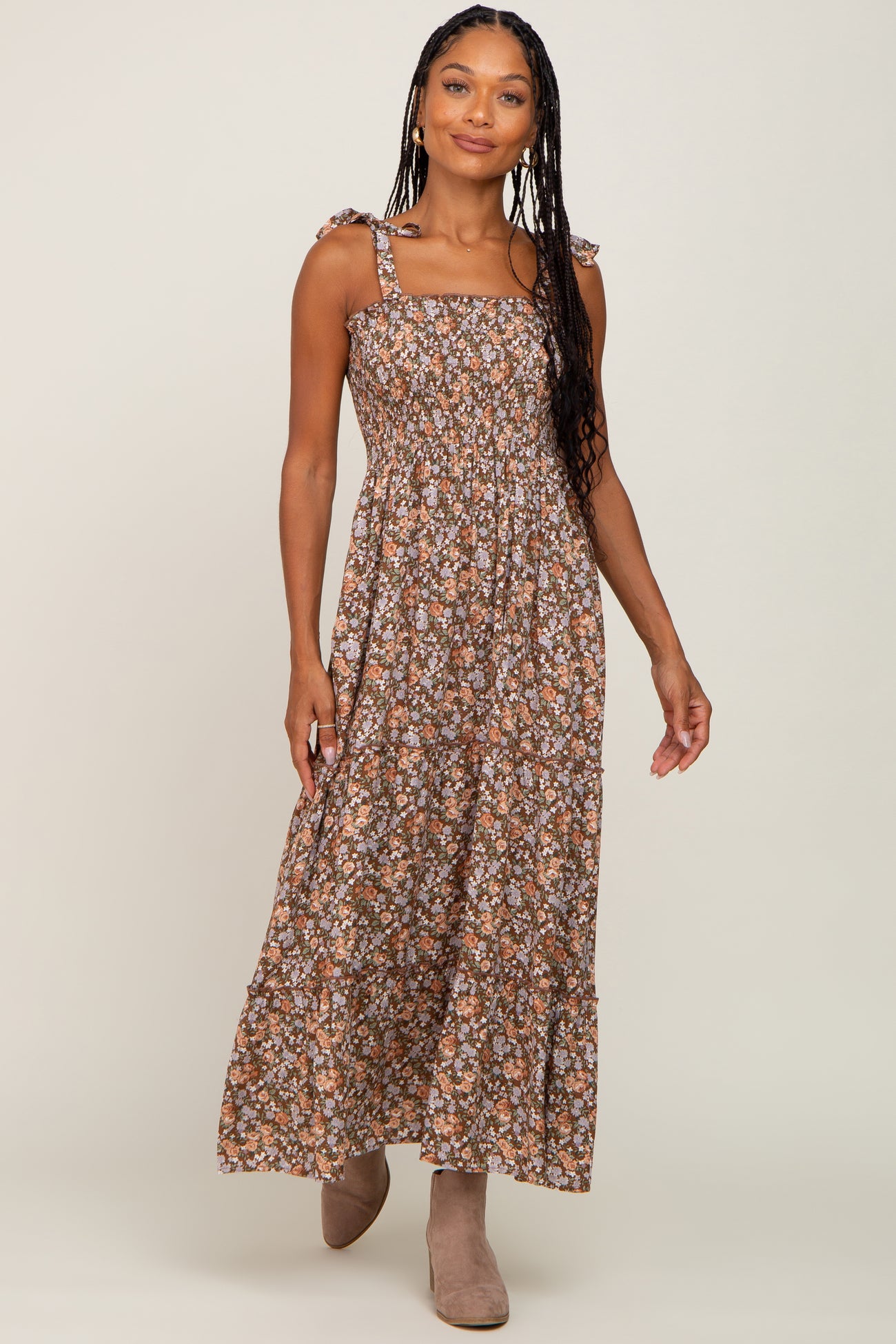 woman wearing a brown floral maxi dress with tie straps and a flowy skirt