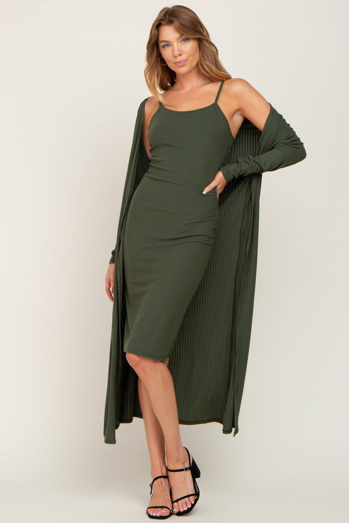 woman wearing an olive green ribbed midi dress with a matching long cardigan and black strappy heels