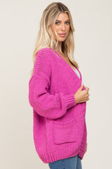 woman wearing a bright pink oversized knitted cardigan with pockets and a relaxed fit