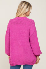 woman wearing a hot pink oversized knit sweater with balloon sleeves and a relaxed fit