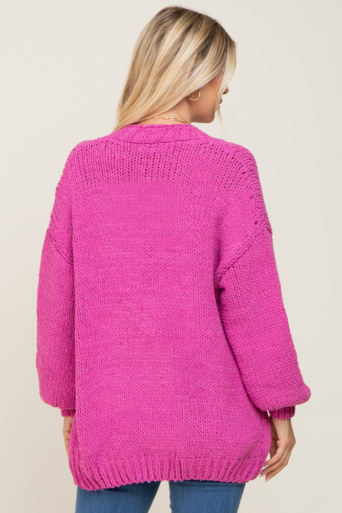 woman wearing a hot pink oversized knit sweater with balloon sleeves and a relaxed fit