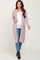 woman wearing a light pink long cardigan with pockets and a white maternity top, showing her baby bump