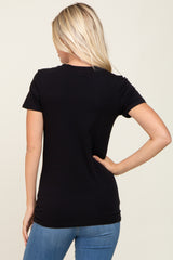 woman wearing a black short sleeve t-shirt and blue jeans, showing the back view of the shirt