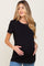 woman wearing a black short sleeve maternity top and holding her baby bump