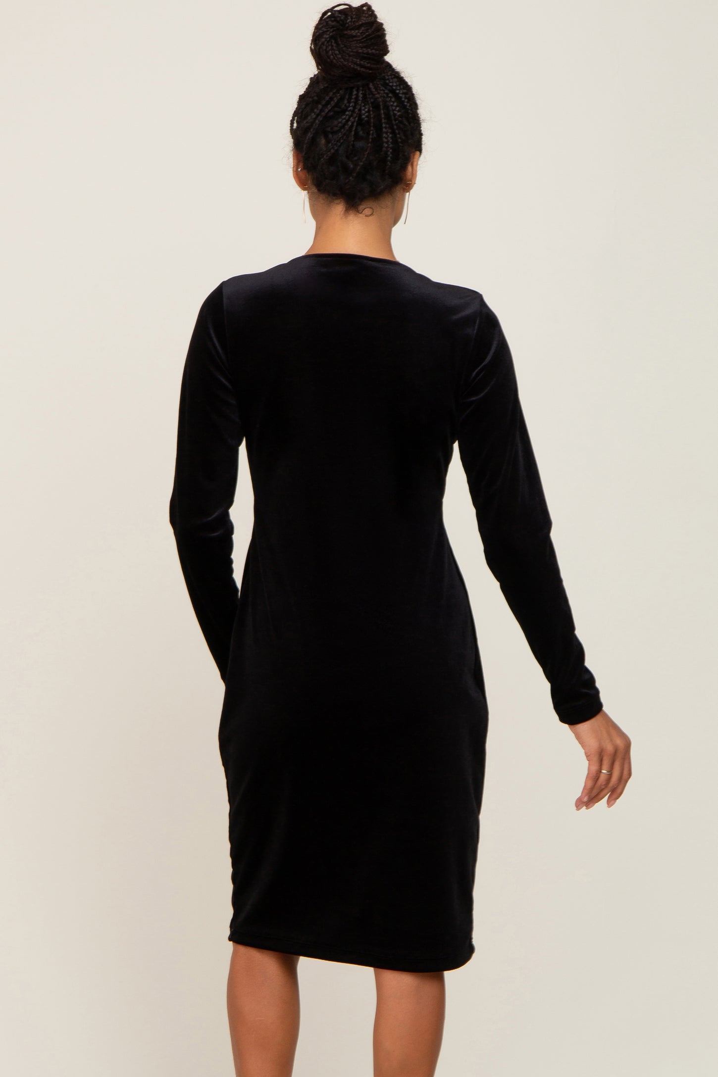 woman wearing a black long sleeve velvet dress from the back