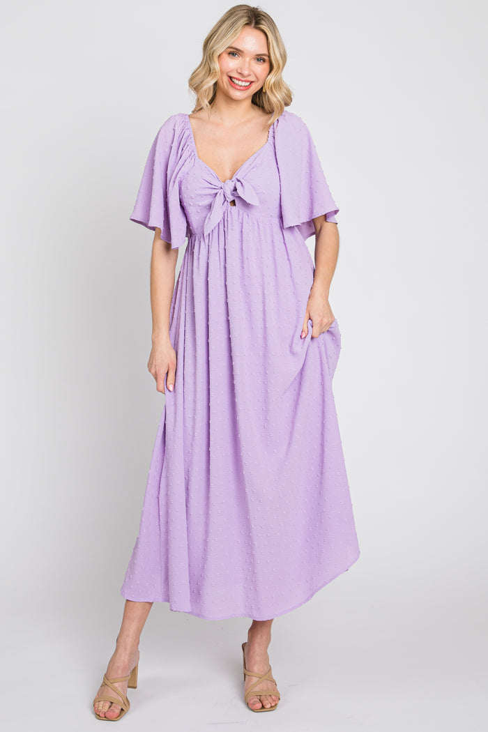 woman wearing a lavender maxi dress with flutter sleeves and a front tie detail