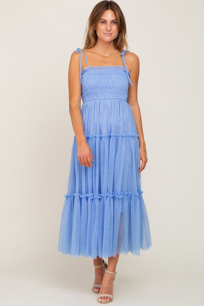 woman wearing a light blue smocked maternity midi dress with tiered tulle skirt and tie straps