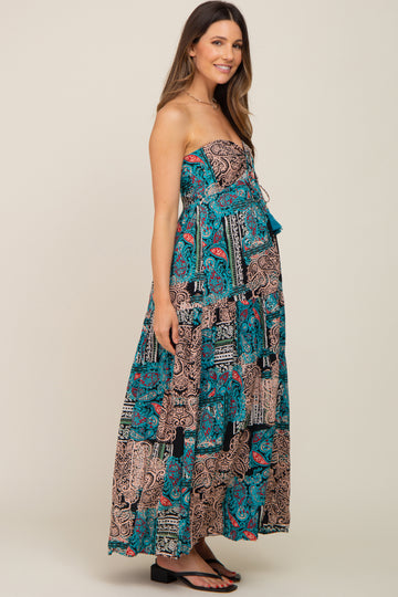 woman wearing a strapless black and turquoise floral print maternity maxi dress with a baby bump visible