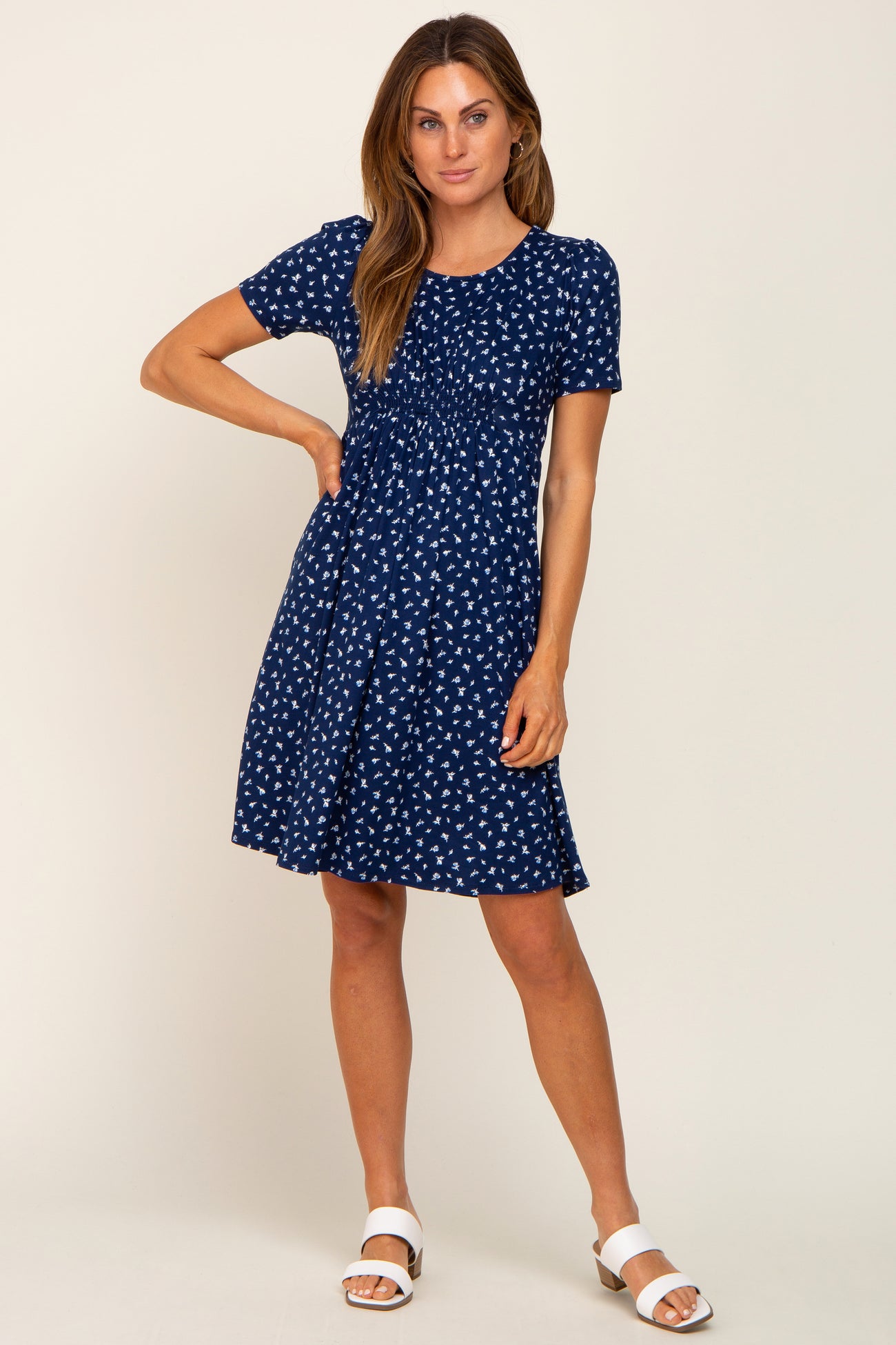 woman wearing a navy blue short sleeve dress with white printed patterns and a flared skirt