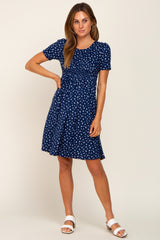 woman wearing a navy blue short sleeve dress with white printed patterns and a flared skirt