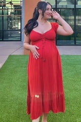 woman wearing a red maternity maxi dress with ruched detailing and a baby bump