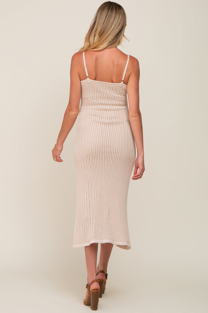 back view of woman wearing beige ribbed knit midi dress with spaghetti straps and brown heels