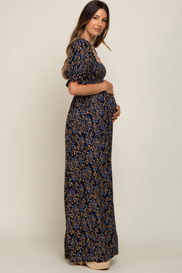 woman wearing a navy floral maternity maxi dress and holding her baby bump