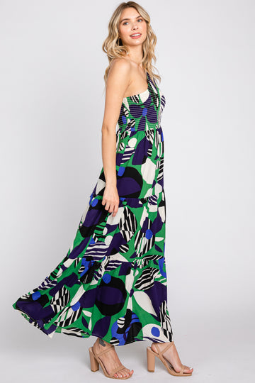woman wearing a colorful patterned maxi dress with a fitted bodice and flared skirt, standing and smiling