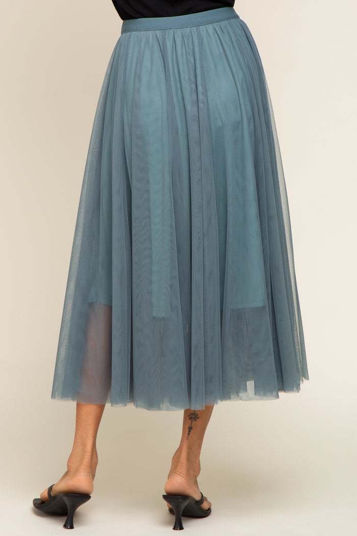 woman wearing a flowy teal midi tulle skirt, showing a layered design and a sheer finish