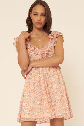 woman wearing a pink floral mini dress with ruffled sleeves and a square neckline