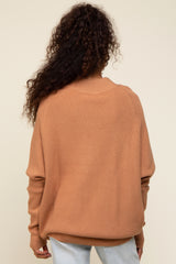 woman wearing a back view of an oversized warm orange knit sweater with long sleeves