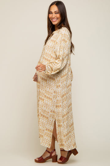 woman wearing a beige and brown patterned maternity maxi dress with a side slit and holding her baby bump